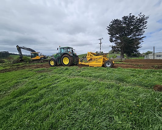 Tractor pulling scraper to start site cut
