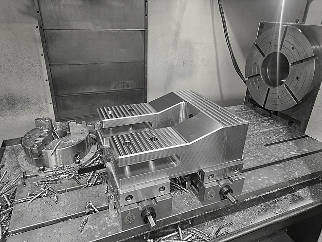 Close-up of CNC-milled aluminium block featuring recessed geometric cavities and sharp internal corners.