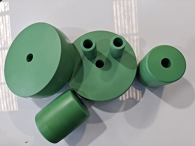 Close-up of CNC-milled aluminium block featuring recessed geometric cavities and sharp internal corners.