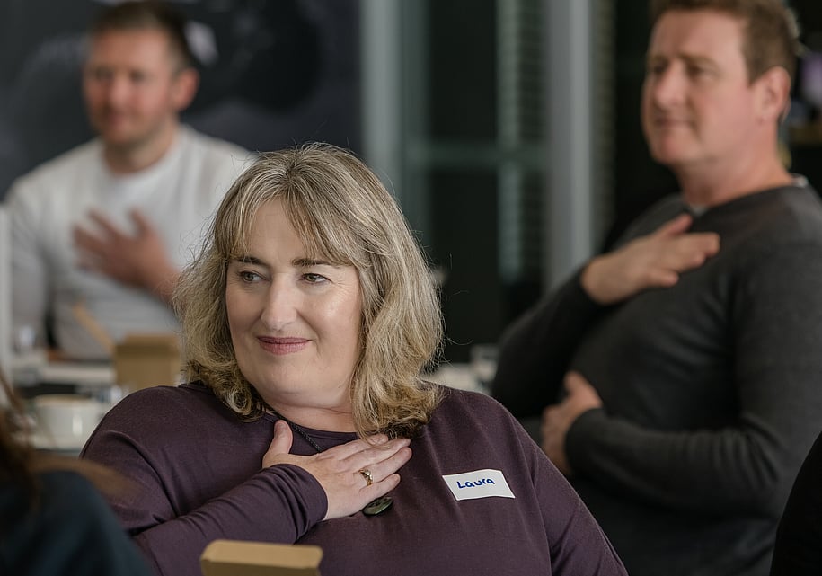 Event guests with hands on chests during a breathing exercise at a workshop event in Papamoa, New Zealand.