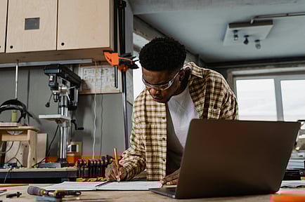 NZ tradie in his workshop working on reconciling accounts before the end of the financial year