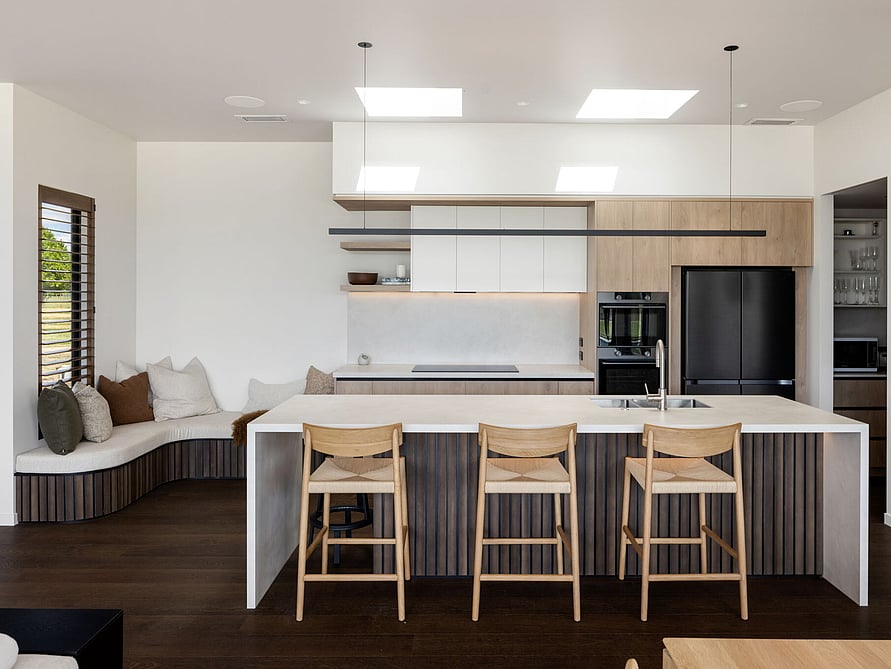 An architecturally designed kitchen with bespoke wooden cabinetry and a white Dekton island in this new build home in Waharoa.