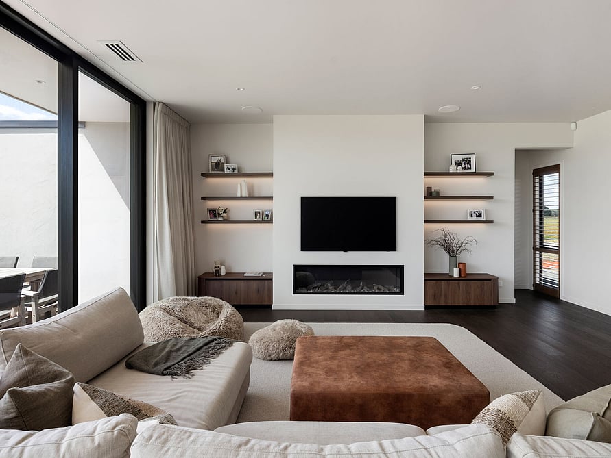 A large corner lounge suite adorns this open-plan living room, creating a cozy space to unwind in this unique modern home.