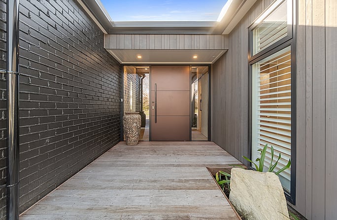Custom-built front door and a bespoke designed entrance features dark and natural tones, make this home truly distinctive.