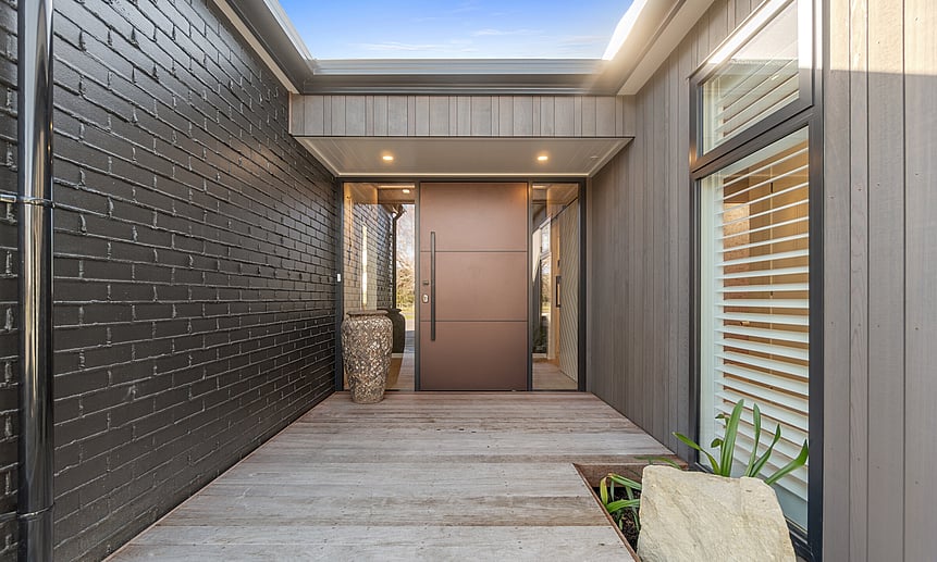 Architectural front entrance with statement door makes for a bold entry in this Master Builder House of the Year Gold winner.