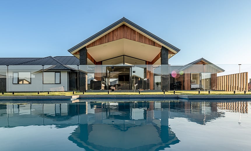 Stylish pool surrounded by glass pool fencing shows the high-quality craftsmanship of the builders at Linecrest Homes.