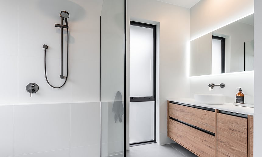 This elegant bathroom, built by Cambridge builders, Linecrest Homes, has a backlit mirror and walk-in shower.