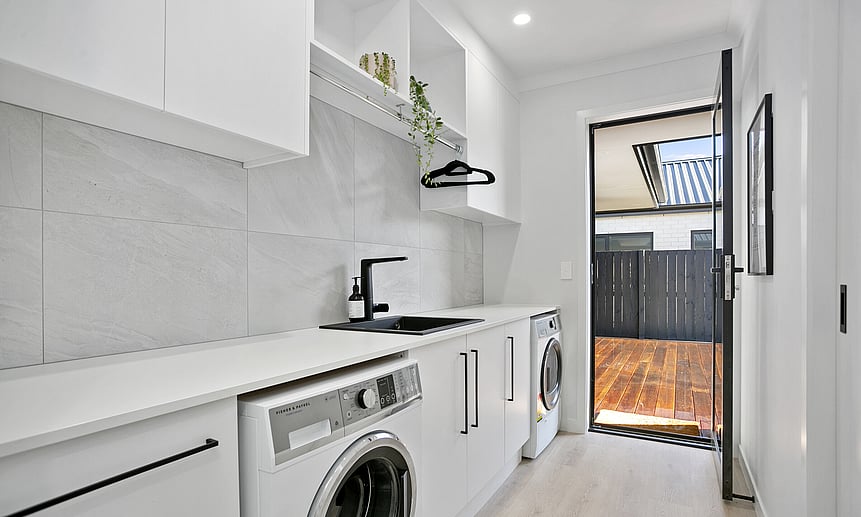 Sleek galley-style laundry featuring custom joinery and minimalist finishes add to a winning build by Linecrest Homes.