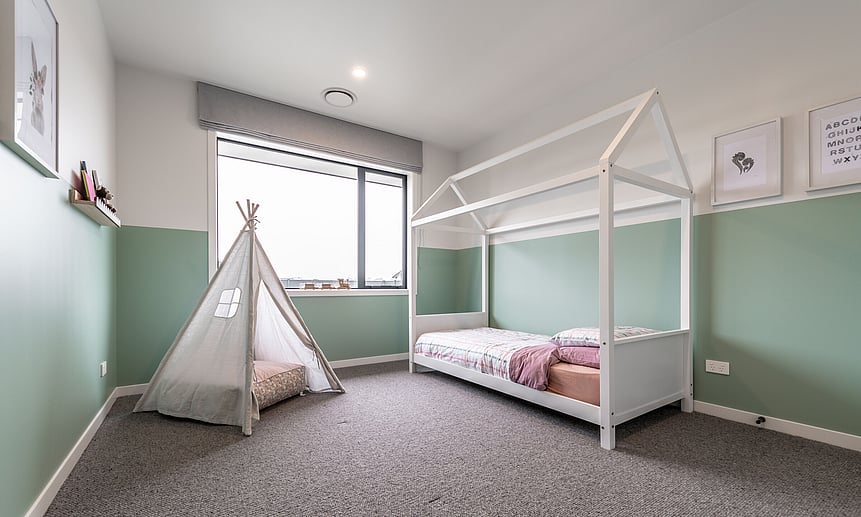 Playfully designed kids&rsquo; room with half-height painted walls and cheerful styling in this new house build.