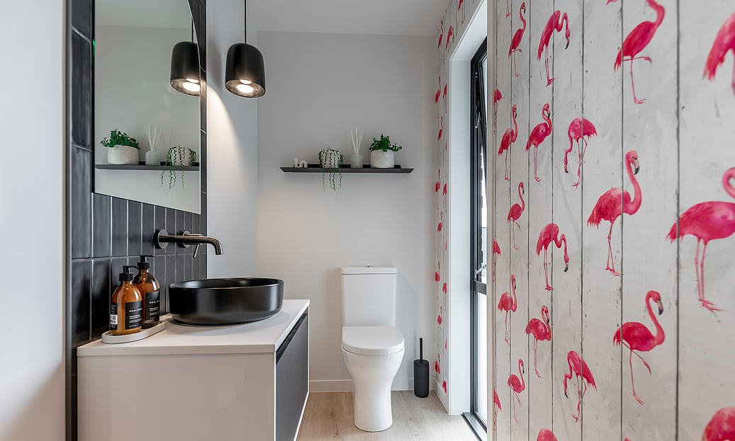 The flamingo feature wall brightens this black and white tiled powder room on this new build in Cambridge, Waikato. 
