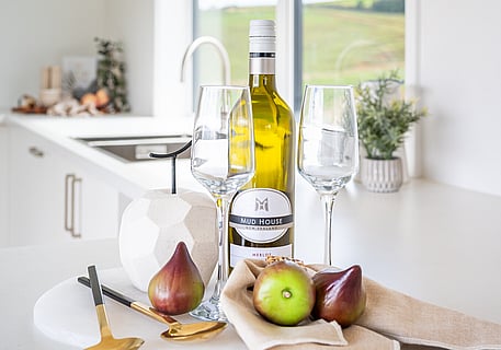 Close up image of wine bottle and glasses on the kitchen benchtop