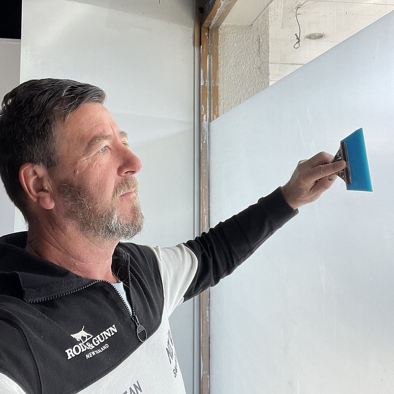 Window Tinter applying frosted film to window