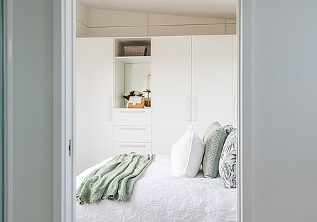 View of bed and storage cupboards in bedroom