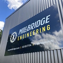 Large vinyl sign on the side of a corrugated building