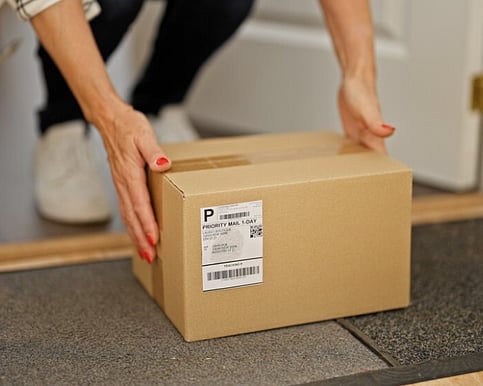 Man handing woman a box of printing