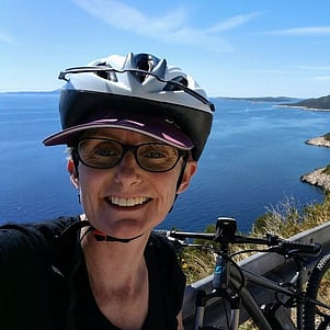 Cyclist and bike looking over Hvar coastline.