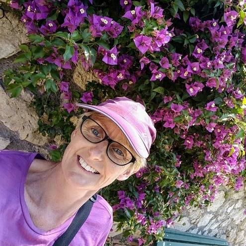 The author standing by a wall of bouganvillia in Capri.