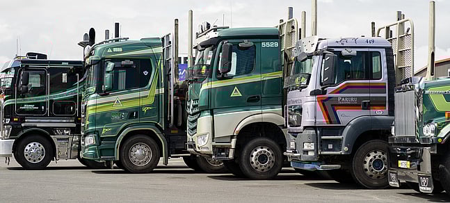Photo of numerous logging trucks lined up in Truckworks' parking lot.