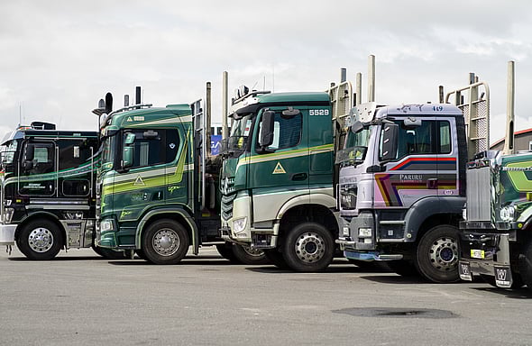 Photo of numerous logging trucks lined up in Truckworks' parking lot.