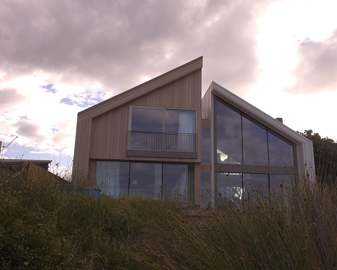 Architectural beachfront home on Ocean Beach Road in Mount Maunganui with large glazing and timber cladding built by Tauranga architectural builder MB Construction