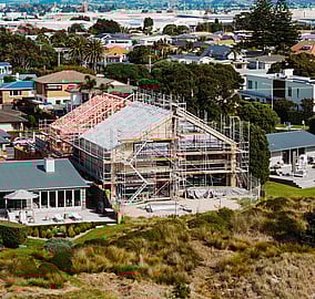 Site view of a bespoke architectural coastal home on Ocean Beach Road in Mount Maunganui, with structural steel and timber framing exposed during construction by MB Construction.