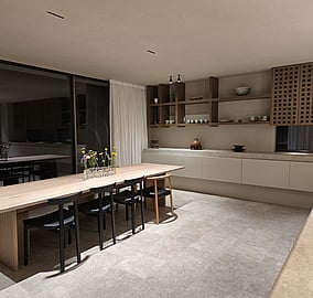 Minimalist dining area with tiled flooring, warm tones and elevated timber shelving above refined wall cabinet drawers in an Ocean Beach Road coastal home in Mount Maunganui.