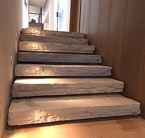 Interior stone stairs in the Ocean Beach Road architectural coastal home leading up to an entry wrapped in cedar cladding in Mount Maunganui, built by Tauranga architectural builders MB Construction.