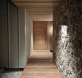 Front entry corridor of the Ocean Beach Road architectural coastal home with cedar cladding, stair access and a bespoke beach ripple front door featuring a custom driftwood handle, built by MB Construction.