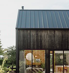 Barn-style architectural rural home near Matamata with cedar cladding and large lounge window facing the rural outlook, built by MB Construction, residential builders for Matamata and the Bay of Plenty.