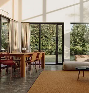 Open-plan living and dining space in an architectural rural home near Matamata with large glazing to the countryside, timber detailing and a warm modern interior, built by MB Construction, residential builders for Matamata and the Bay of Plenty.