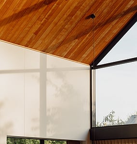 Living room in an architectural rural home near Matamata with timber-lined raking ceiling, feature paper pendant and large glazing to the countryside, built by MB Construction, residential builders for Matamata and the Bay of Plenty.
