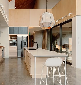 Kitchen in an architectural rural home near Matamata with generous island bench, birch ply joinery and warm modern detailing, built by MB Construction, residential builders for Matamata and the Bay of Plenty.