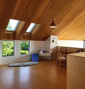 Mezzanine study in an architectural rural home in Matamata with raked timber ceiling, skylights, cork flooring and built-in desk overlooking the living area, crafted by MB Construction.