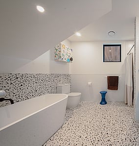 Family bathroom in an architectural rural home in Matamata featuring terrazzo tiles, blue vanity and walk-in shower, designed and built by MB Construction.