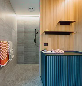 Main ensuite walk-in shower in an architectural rural home in Matamata with terrazzo floor, tiled walls and frameless glass screen, built by MB Construction.