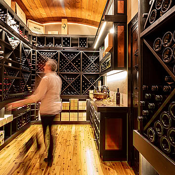 man walking through his wine cellar. 