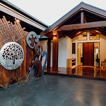 Rustic timber entranceway with metal art scupltures.