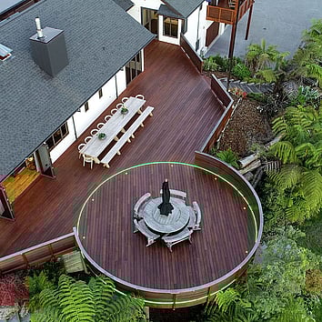 Arial view of large family home and large deck surrounded by New Zealand native bush.
