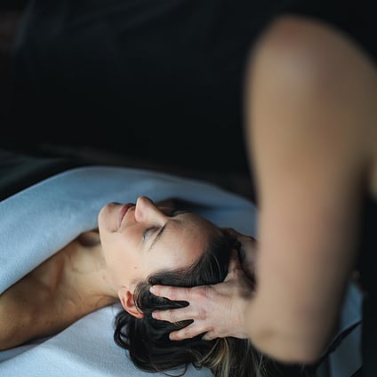 A client receiving a gorgeous head massage during a facial treatment.