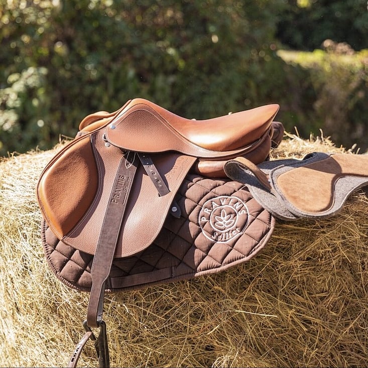 saddle with leathers on a hay bale