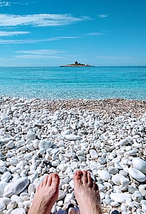The authors feet at an empty beach in Croatia.