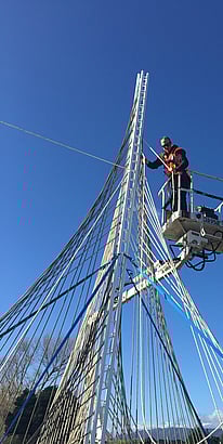 Ben Lowry Hoyle working at heights on the woven rope sculptures that form part of Te Huarahi landscape.