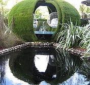 Suspended acrylic bubble chairs float inside grass covered creation by Ben Hoyle Design