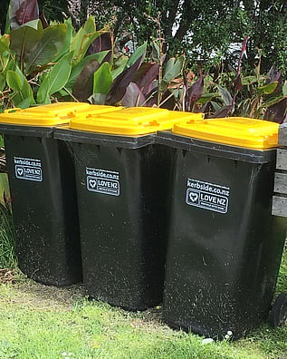 Three TCDC recycling bins left on the kerbside in Kuaotunu on the Coromandel Peninsula