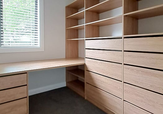 Text overlay on an image showing a custom walk-in wardrobe.