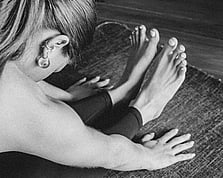 A person in the seated forward fold, or Paschimottanasana, position