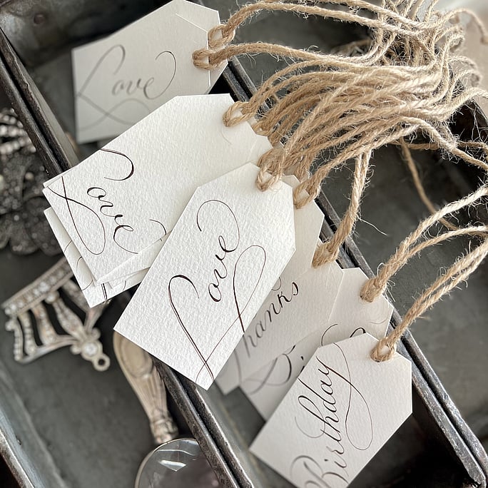 A collection of our gift tags handwritten in walnyt ink. Can we secured to a gift by the string