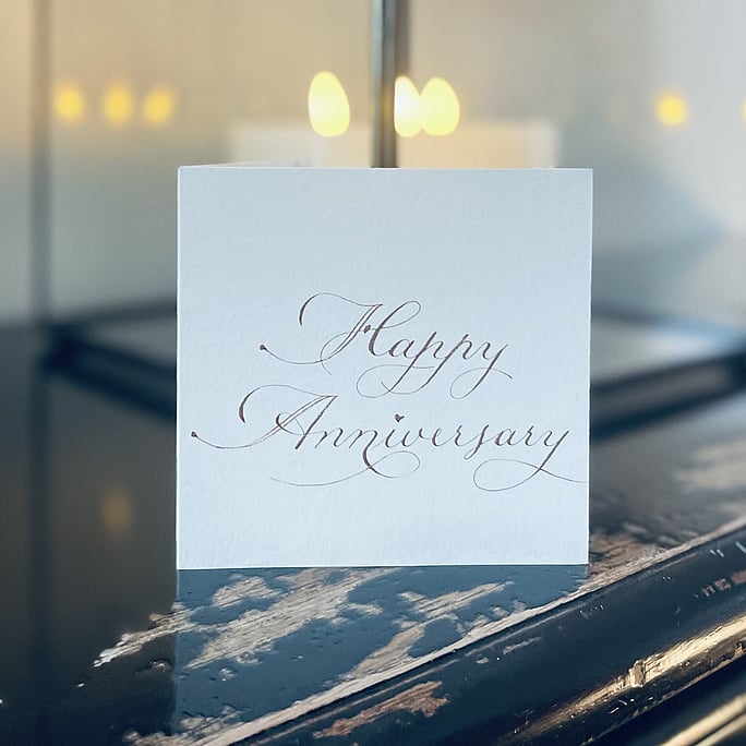 Our flourished happy anniversity card lettered in rose finetec watercolour paint