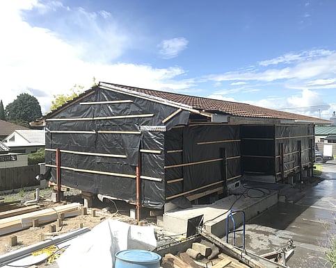 The house on the original site had all services carefully disconnected and was wrapped in protective polyethylene, ready to be lifted and transported by the house moving company.