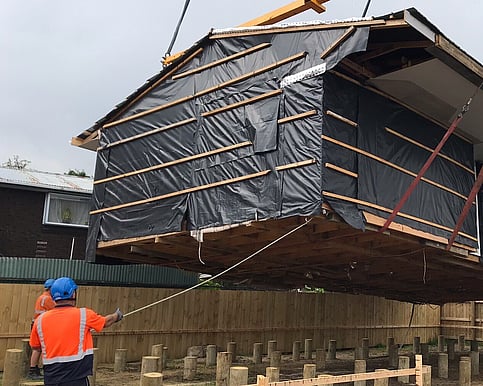 The house is being craned onto the transport truck and delivered to new site. 